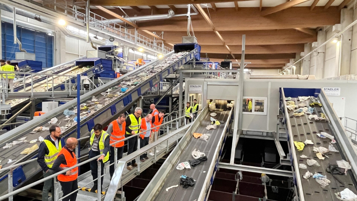 Workers inspecting plastic waste on recycling conveyor belts in Europe facility