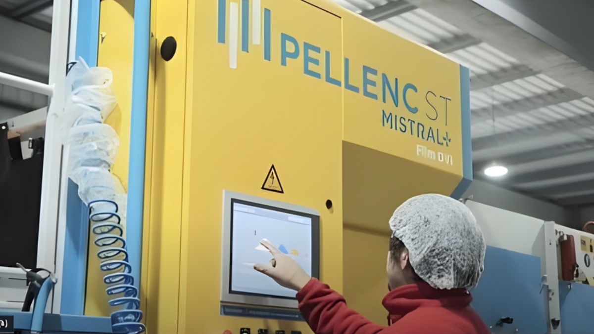 Operator using AI-enabled plastic sorting machine inside recycling facility