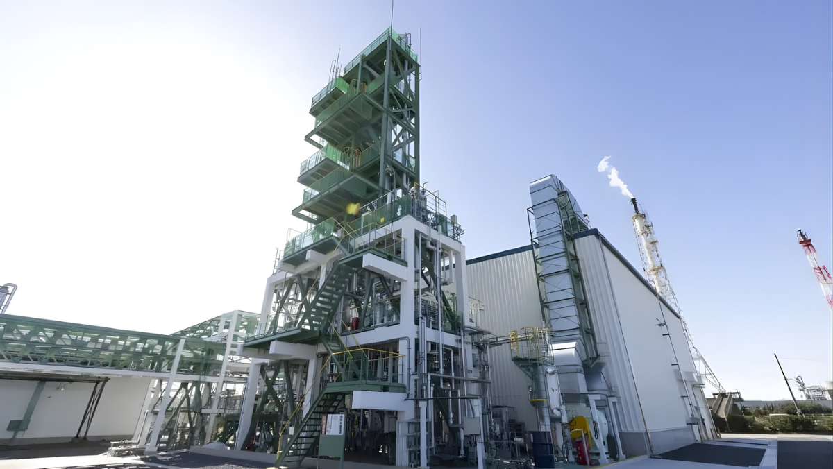 Industrial recycling plant structure with metal platforms under clear sky.