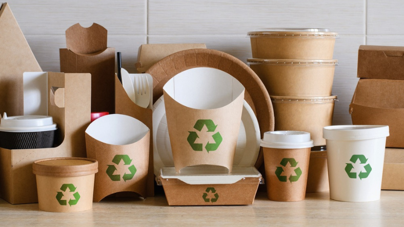 Recyclable bioplastic food packaging including cups, trays and containers displayed together
