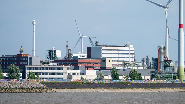 Industrial plastics and chemical processing facility with wind turbines nearby