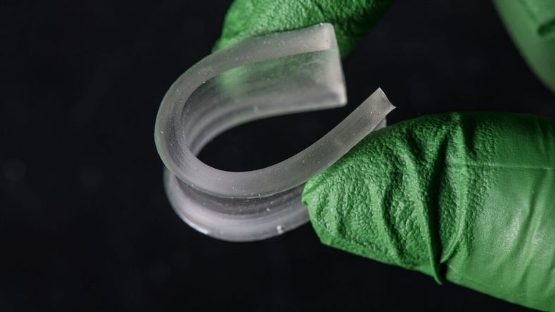 Flexible bio-based polymer sample held in laboratory glove