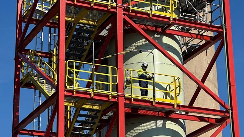 Industrial worker inspecting equipment at waste plastic recycling facility
